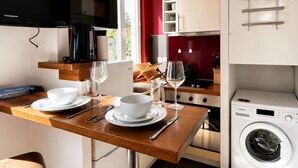 Una cucina compatta con forno a microonde, macchina del caffè e lavatrice.
