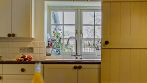 A kitchen with a window, a sink, and cabinets. - 3 Bed in Wells-next-the-sea (oc-ncc68) (Stiffkey)