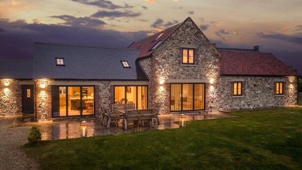A stone house with a large patio, a dining area, and a view of the sky. - 4 Bed in Bedale (oc-80704) (Newton-le-Willows)
