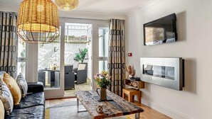 Uma sala de estar moderna com sofá, mesa de centro, TV e vista para o exterior.
