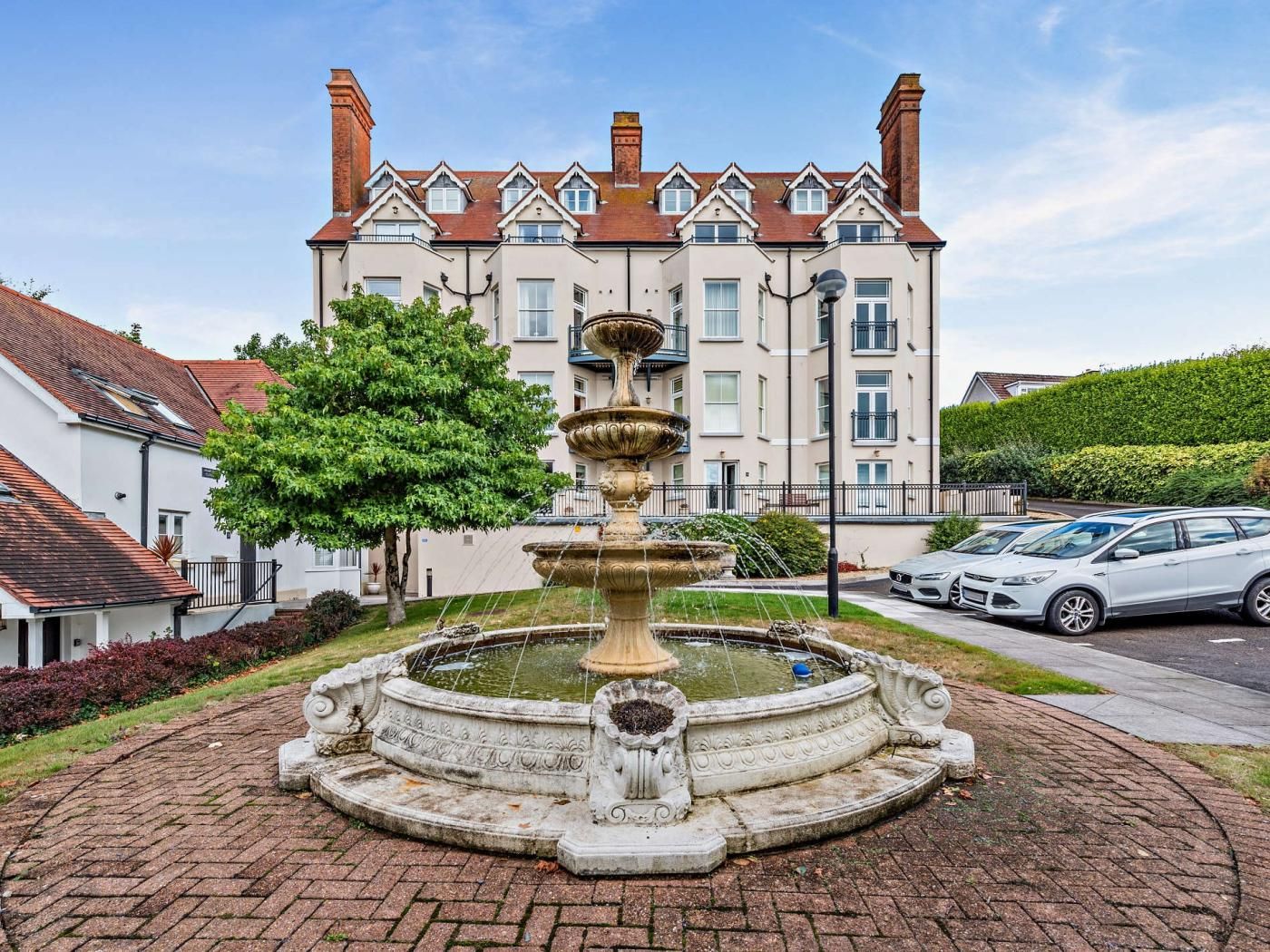 A fountain in a courtyard with a building in the background.
