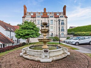 A fountain in a courtyard with a building in the background. - 2 Bed in Tenby (oc-fb032) (Tenby)