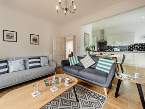 A modern living room with a grey sofa, a coffee table, and a patterned rug. - 3 Bed in Tenby (oc-73606) (Tenby)
