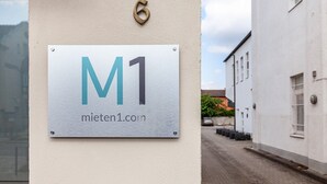 A sign on a wall with the text 'M1' and 'miiten1.com'.