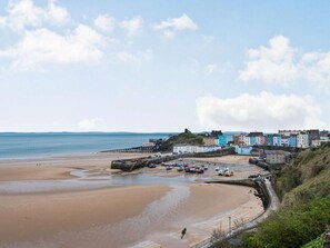 A coastal town with colorful buildings, a sandy beach, and a pier. - 1 Bed in Tenby (oc-fb056) (Tenby)