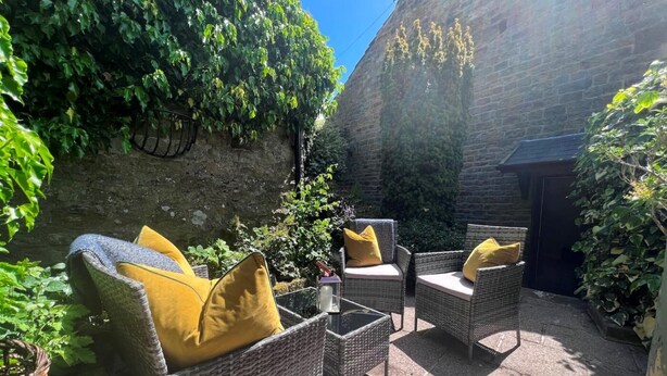 Wicker furniture with cushions, a stone wall, and greenery. - 2 Bed in Harrogate (oc-g0017) (Lofthouse)