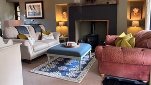 A living room with a sofa, a red couch, a fireplace, and a lamp. - 2 Bed in Harrogate (oc-g0017) (Lofthouse)