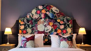 A bed with a quilted cover, two bedside lamps, and a floral-patterned headboard. - 2 Bed in Harrogate (oc-g0017) (Lofthouse)