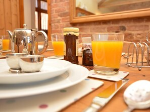 A breakfast setting with a teapot, sugar bowl, and a glass of orange juice on a wooden table. - 2 Bed in Market Rasen (oc-73853) (East Barkwith)