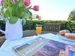 A table with a pitcher, a glass of orange juice, a plate of pastries, and a welcome brochure. - 2 Bed in Market Rasen (oc-73853) (East Barkwith)