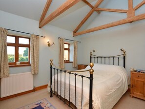 A bedroom with a bed, wooden beams, a radiator, and a window with curtains. - 2 Bed in Market Rasen (oc-73853) (East Barkwith)