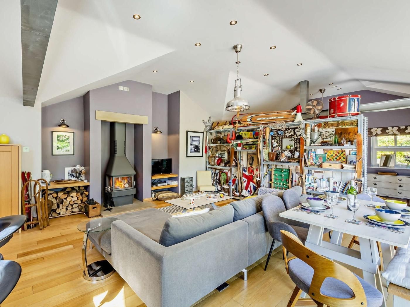 Un salon moderne doté d’une cheminée, d’un coin repas et d’une collection d’objets de collection liés au sport.