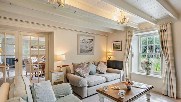 Ett mysigt vardagsrum med en soffa, ett soffbord och ett fönster med gardiner.