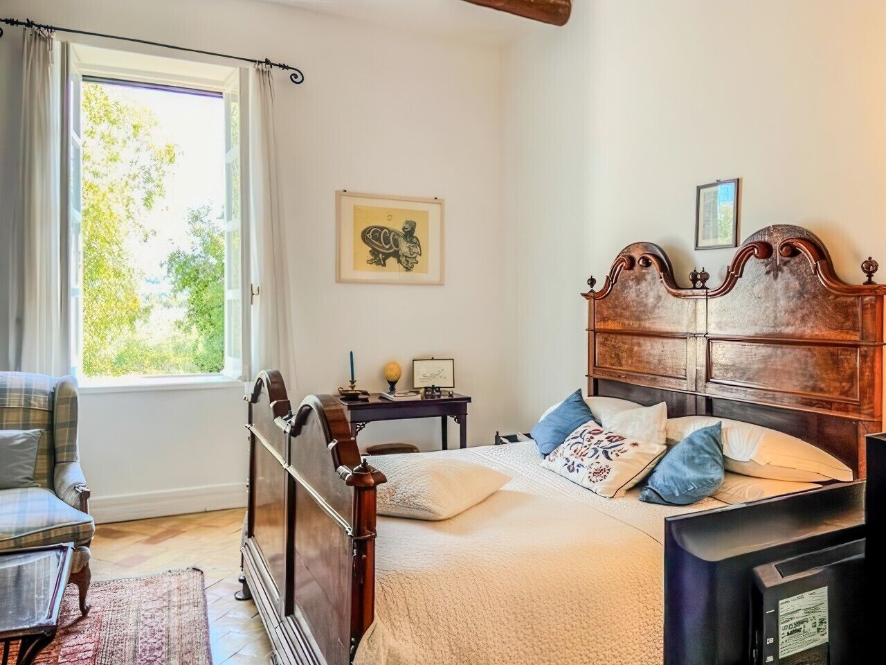 Une chambre à coucher avec un lit en bois, un bureau, une chaise et une fenêtre avec des rideaux.
