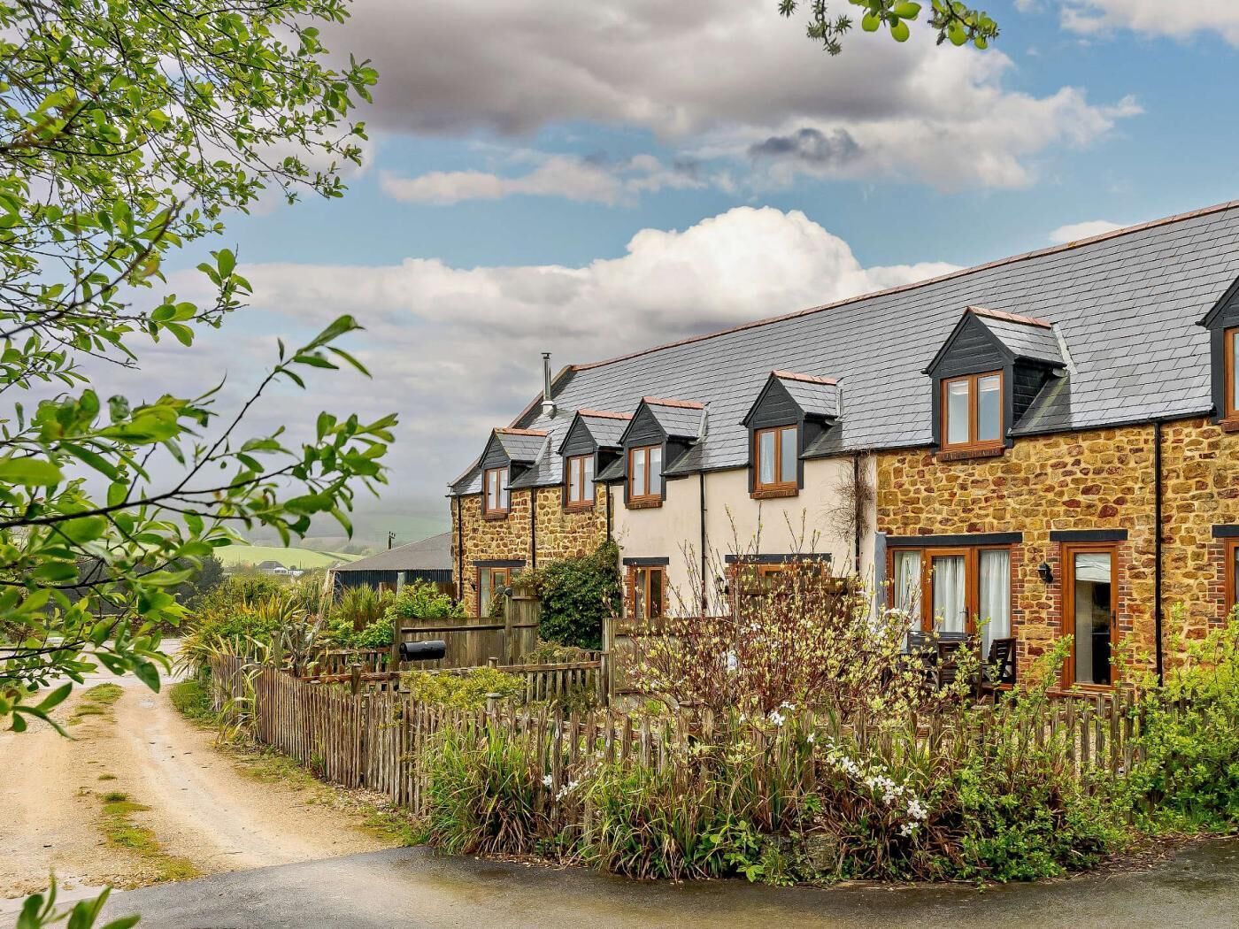A row of stone houses with pitched roofs and wooden fences.