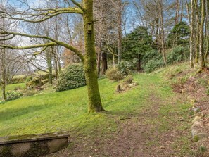 A natural landscape with a grassy path, trees, and a stone bench. - 2 Bed in Wasdale (oc-sz053) (Wasdale)