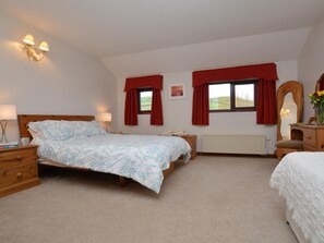 A bedroom with a bed, bedside tables, a dresser, a radiator, and a window with curtains. - 2 Bed in Bridport (oc-dc162) (Chideock)