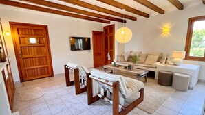 Una sala de estar con sofá, mesa de centro y sillas de madera.