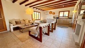 Una sala acogedora con un sofá, una mesa de centro de madera y un sillón estampado.