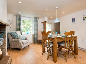 Ein Essbereich mit einem Holztisch, Stühlen und einer Hängelampe.