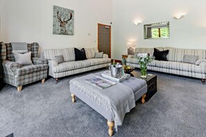 A living room with two sofas, a coffee table, and a door. - 6 Bed in Bideford (oc-75553) (Buckland Brewer)