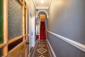 Hallway with original mosaic tiling leading to the staircase.