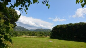 A grassy field with a fence, trees, and hills in the background. - 3 Bed in Dolgellau (oc-75737) (Dolgellau)