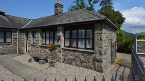A stone building with a pitched roof, a chimney, and a window with a flower box. - 3 Bed in Dolgellau (oc-75737) (Dolgellau)