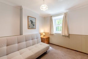 A room with a sofa, a bedside table with a lamp, a window with curtains, and a framed picture on the wall. - 4 Bed in Wasdale (oc-sz326) (Wasdale)