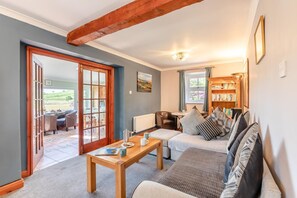 Ein gemütliches Wohnzimmer mit einer Couch, einem Couchtisch und einem Bücherregal.