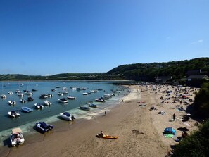 A beach with boats, a sandy shore, and houses in the background. - 5 Bed in Llanybydder (oc-75907) (Brynteg)