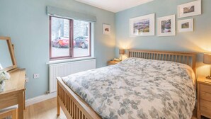 A bedroom with a bed, bedside tables, a window, and framed pictures on the wall. - 1 Bed in Keswick (oc-85419) (Keswick)