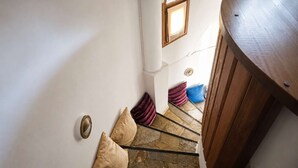 Eine Treppe mit Steinstufen, einem Holzgeländer und einer Wandleuchte.