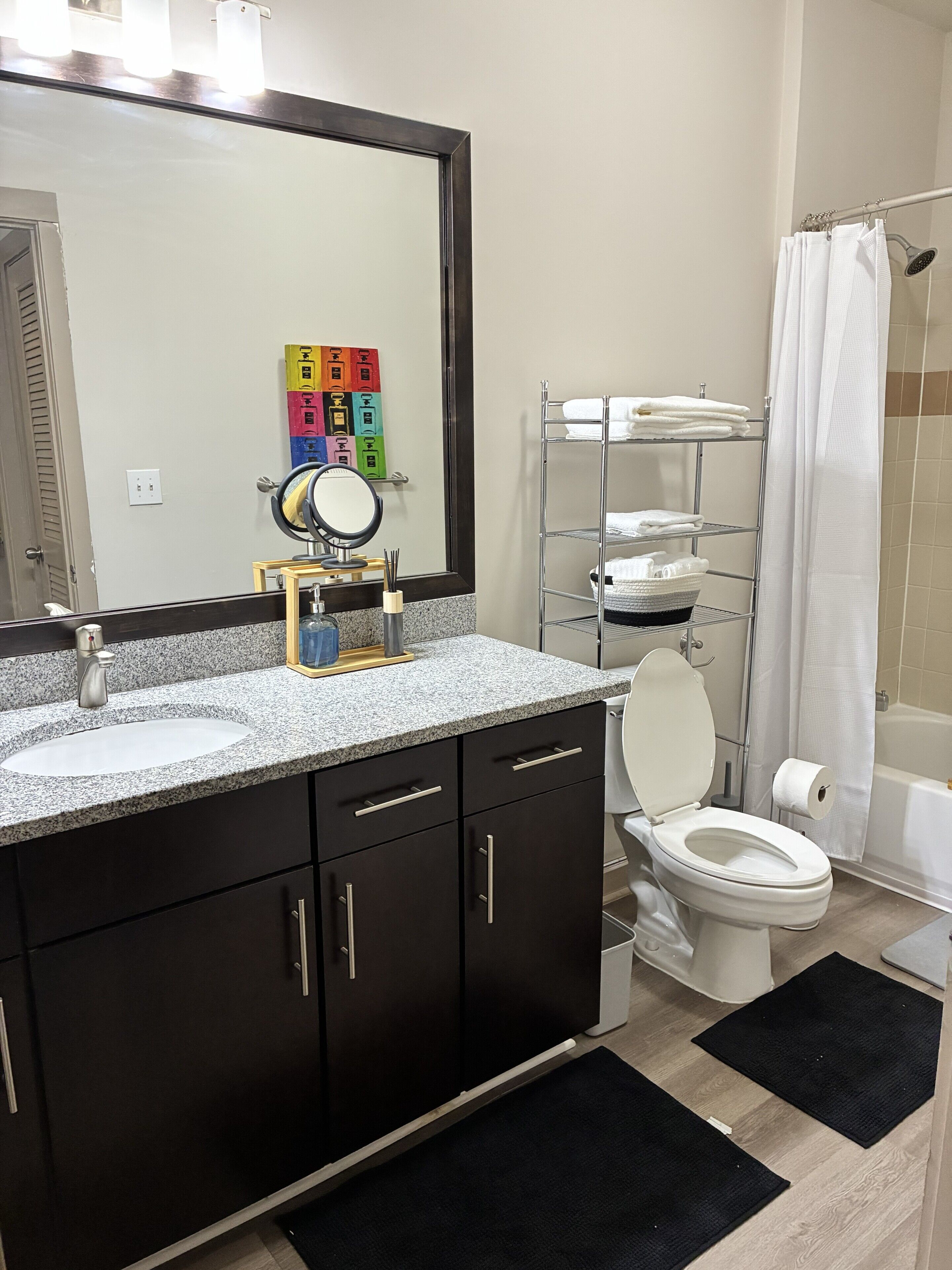 Un baño con lavamanos, espejo, inodoro y cabina de ducha.