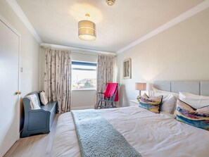 A hotel room with a bed, a desk, a chair, a window with curtains, and a ceiling light. - 4 Bed in Isle Of Arran (oc-n42556) (Whiting Bay)