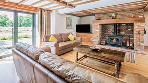 A living room with a sofa, a coffee table, a fireplace, and a television. - 5 Bed in Ashford (oc-76428) (Smarden)