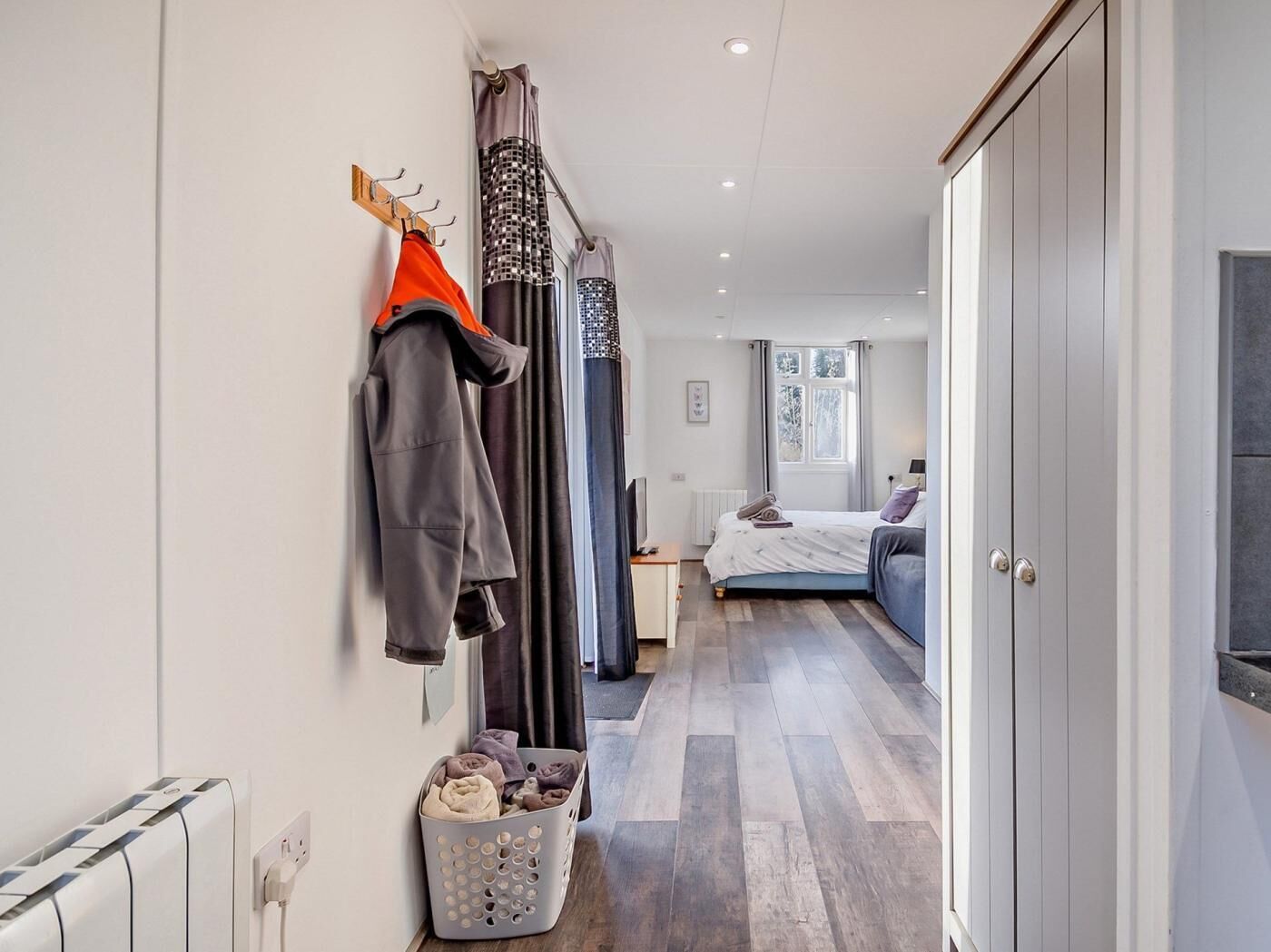 Une chambre à coucher avec un lit, une table de chevet, une fenêtre et une armoire.