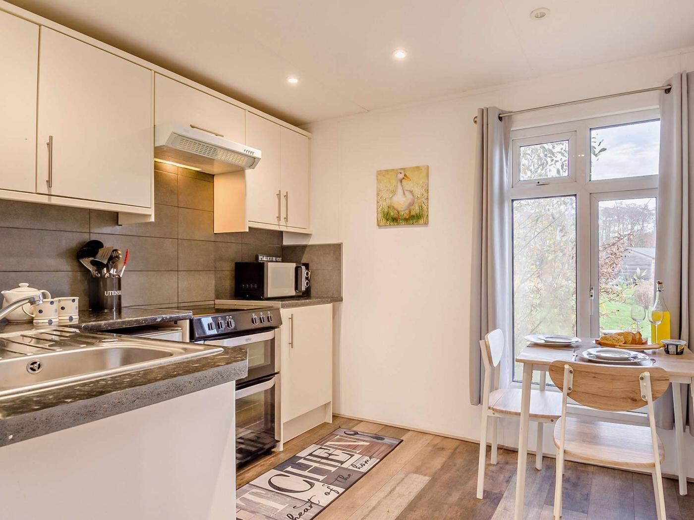 A modern kitchen with a built-in oven, microwave, and stainless steel sink.