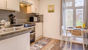 A modern kitchen with a built-in oven, microwave, and stainless steel sink. - 1 Bed in Norwich (oc-76493) (East Harling)