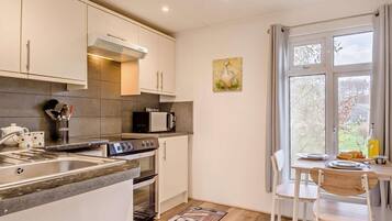 A modern kitchen with a built-in oven, microwave, and stainless steel sink.