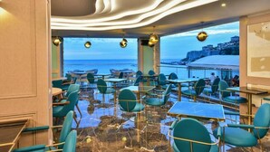 Restaurante con terraza al aire libre y vistas a la costa, con una decoración moderna y vista al mar.