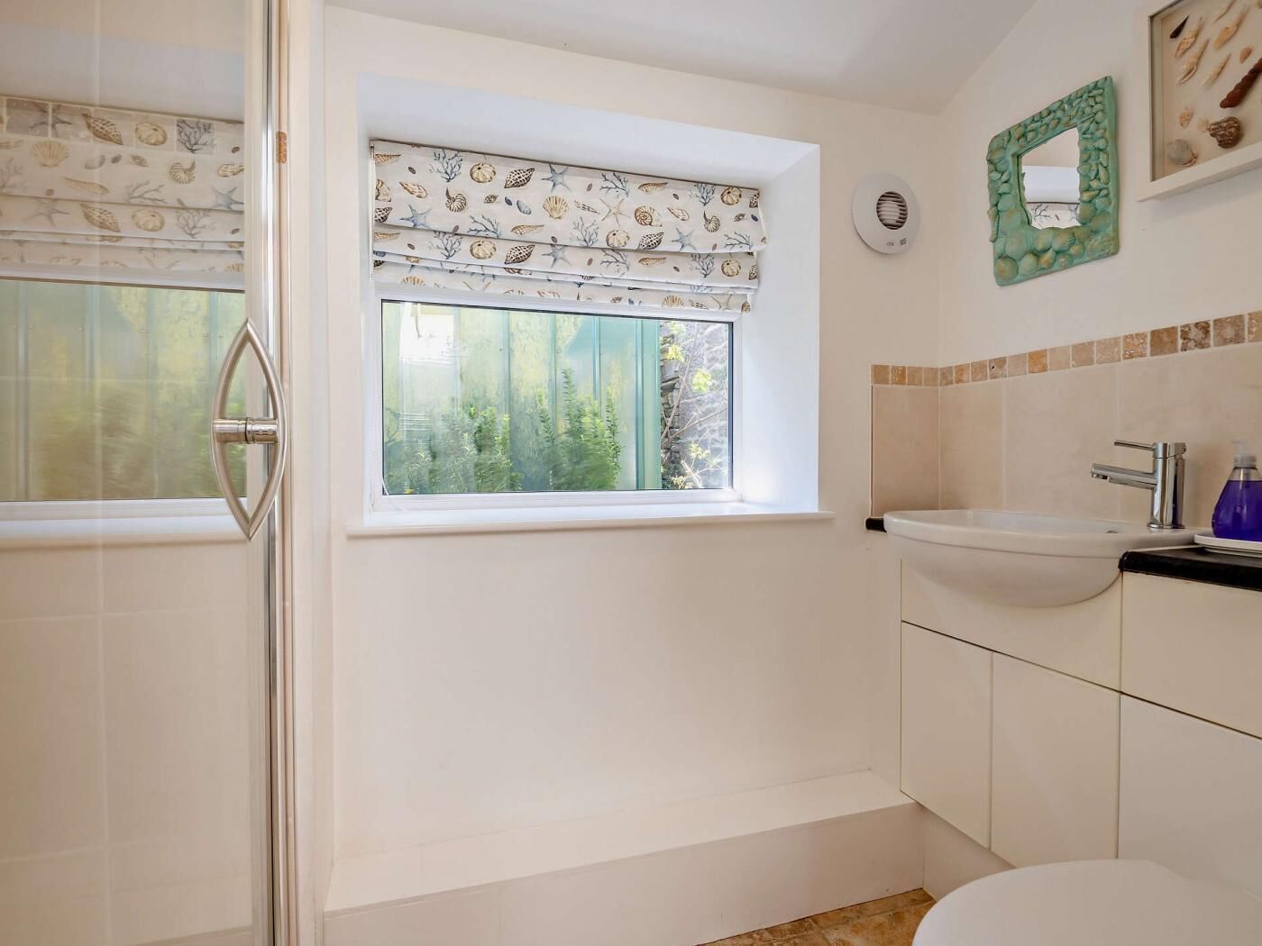 Baño con ventana, lavamanos y espejo.