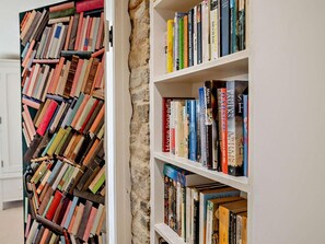 Ein Bücherregal mit verschiedenen Büchern und eine Wand mit einem einzigartigen, abstrakten Muster.