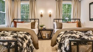 Un dormitorio con dos camas, una mesita de noche y una ventana con cortinas.