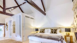 Ein Schlafzimmer mit Bett, Nachttisch, Kleiderschrank und Spiegel.
