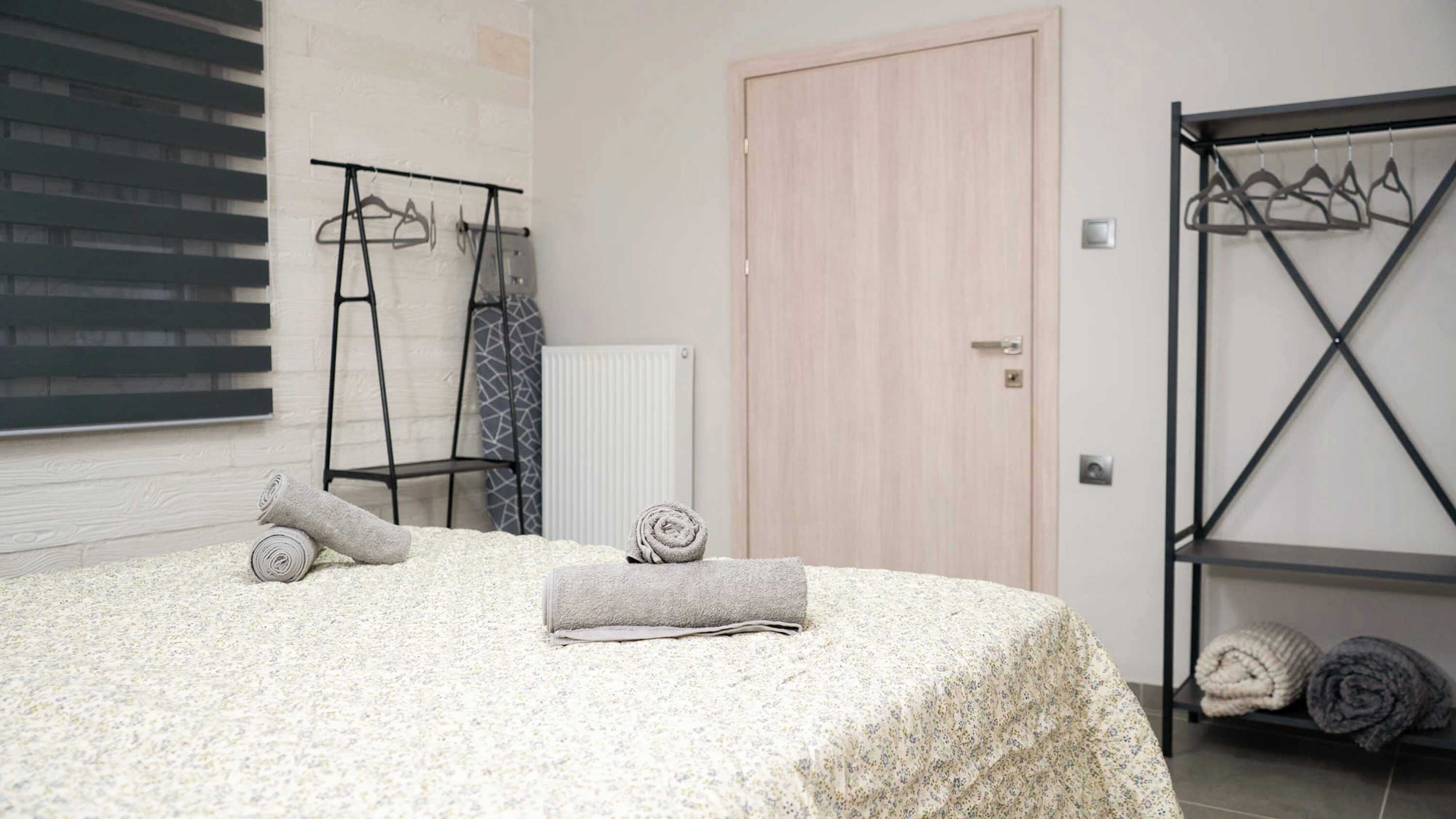 Une chambre à coucher avec un lit, un radiateur, une porte en bois et un porte-serviettes en métal.