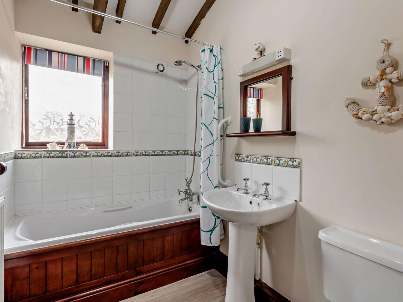 A bathroom with a bathtub, a sink, and a shower curtain.