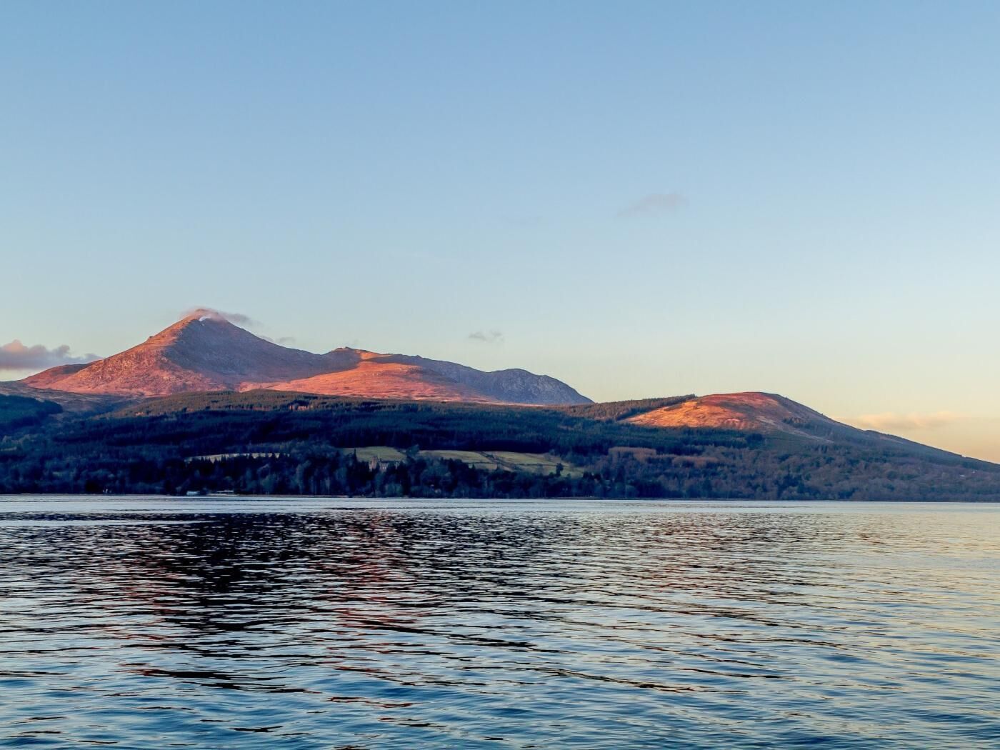 Une chaîne de montagnes avec un lac au premier plan.