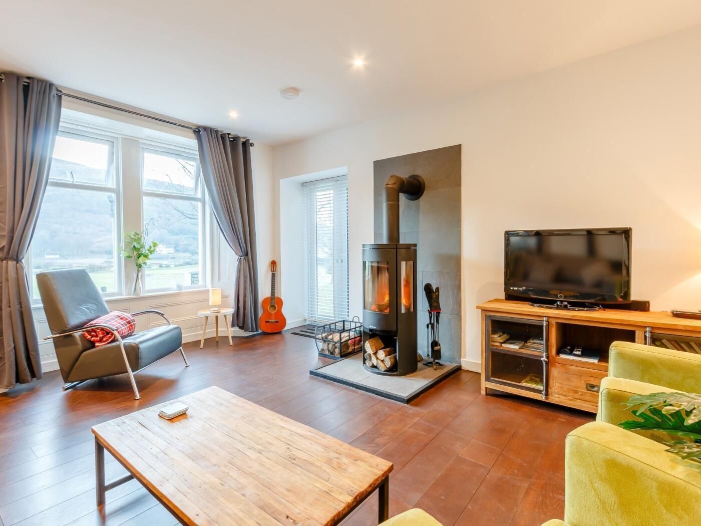 A modern living room with a fireplace, a television, and comfortable seating.