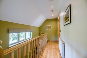 A hallway with a wooden staircase, a radiator, and a window with a white blind. - 2 Bed in Chathill (oc-77990) (Ellingham)